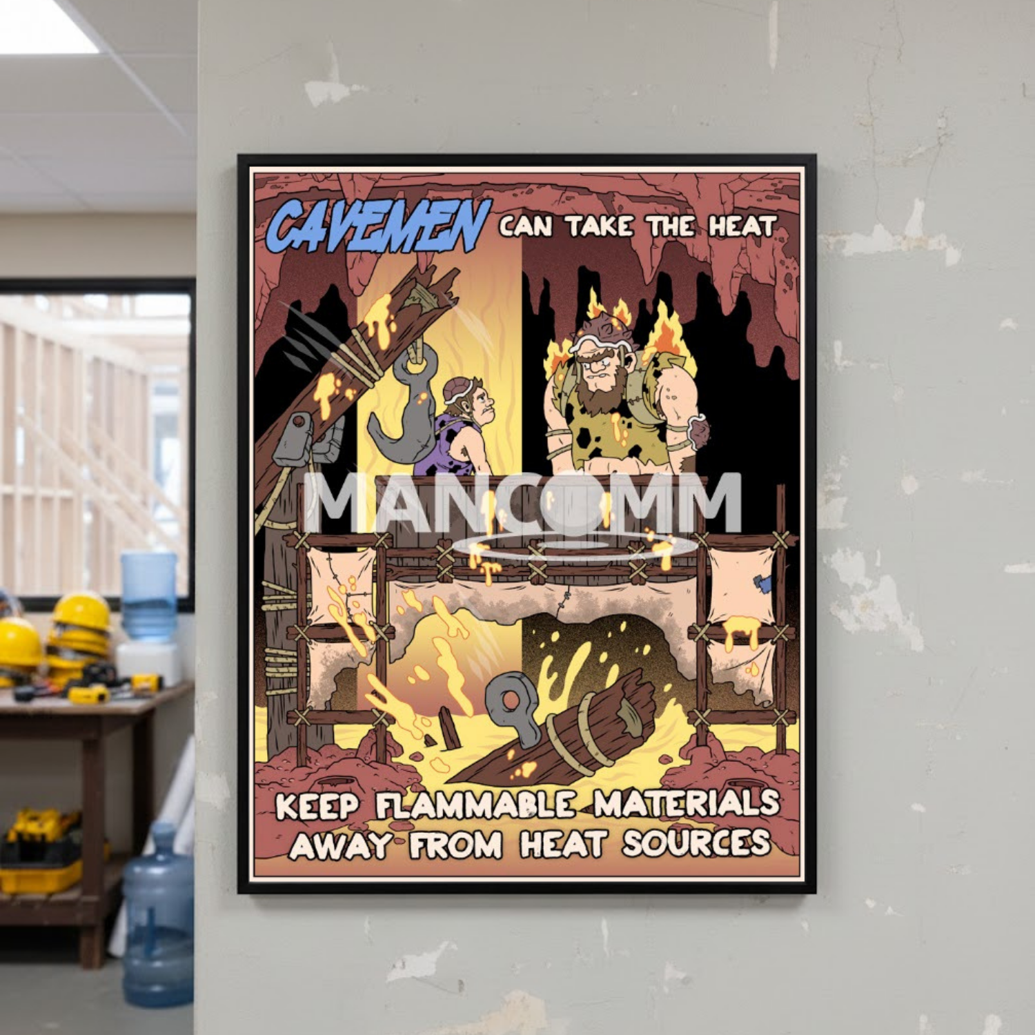 Cartoon-style safety poster on a wall with text 'Cavemen can take the heat' and 'Mancomm' branding.