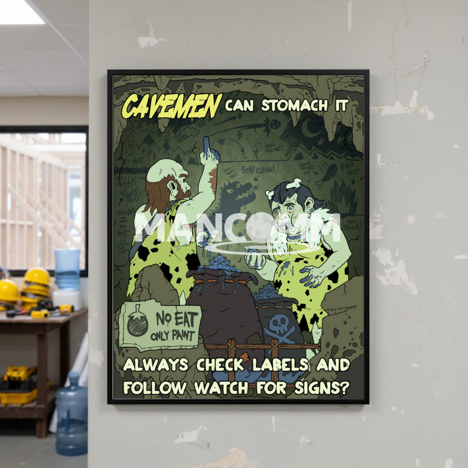 Cartoon poster with cavemen and text on a wall in an office setting