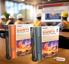 Two spiral-bound Essentials of Safety OSHA construction trainer manuals displayed on a desk in a classroom setting, with workers in hard hats and safety vests attending a presentation in the background and a branded USB drive beside the books.